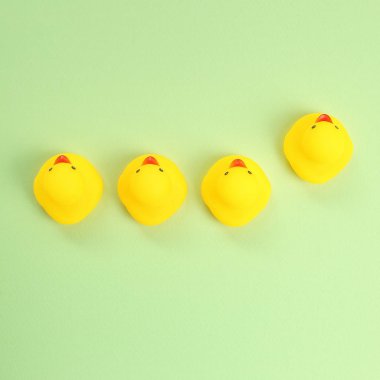 Yeşil arka planda sarı plastik ördek bebeği