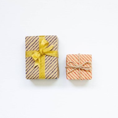 Beyaz arkaplanda çizgili kraft kağıdına sarılı hediye kutuları