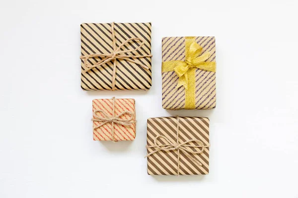 Gift boxes wrapped in striped kraft paper on white background — Stock Photo, Image