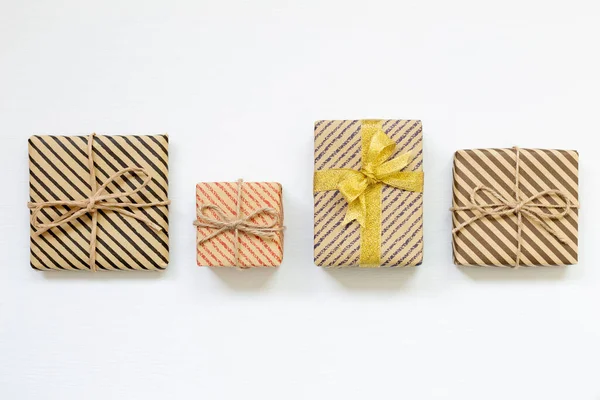 Beyaz arkaplanda çizgili kraft kağıdına sarılı hediye kutuları — Stok fotoğraf