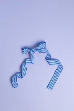 Çizgili desen mavi kurdele mor arkaplanda izole edilmiş.
