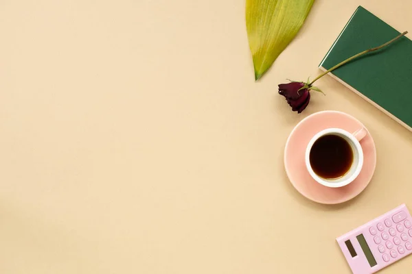 Work and study place. note book, cup of coffee, calculator with floral decoration. flat lay, top view, copy space