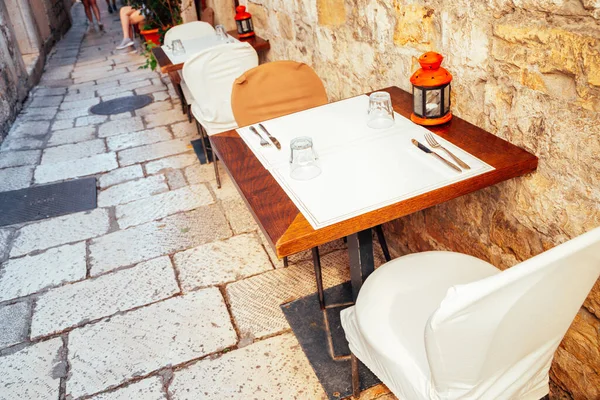 Old town narrow alley with restaurant tables and chairs in Split, Croatia