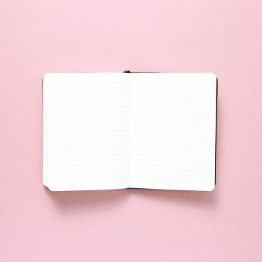Pembe arka planda boş defter. Üst görünüm, boşluk kopyala