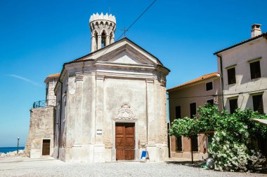 Slovenya 'nın Piran kentindeki eski deniz feneri ve eski kilise