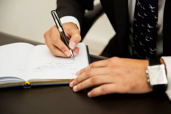 Empresario escribiendo notas en un cuaderno —  Fotos de Stock