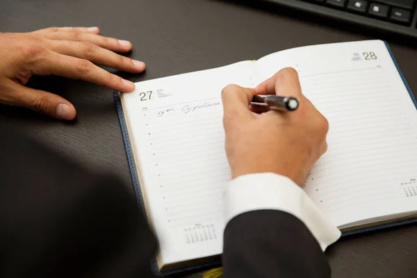 Empresário escrevendo notas ser caneta em um caderno — Fotografia de Stock