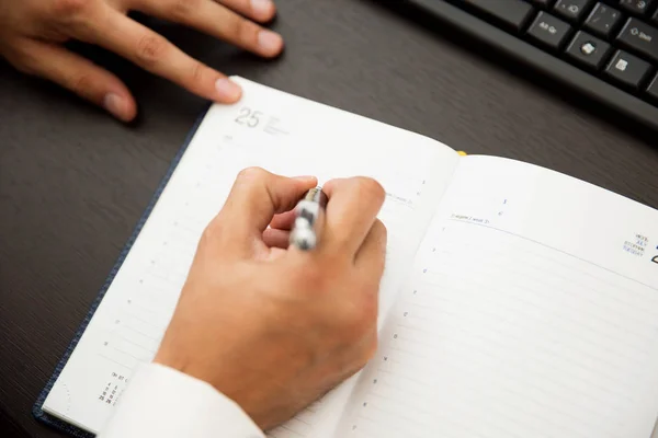 Empresário escrevendo notas ser caneta em um caderno — Fotografia de Stock