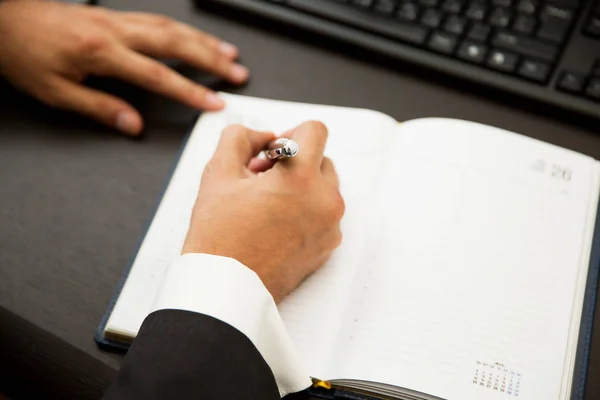 Empresário escrevendo notas ser caneta em um caderno — Fotografia de Stock