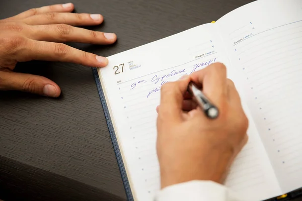 Empresário escrevendo notas em um caderno — Fotografia de Stock