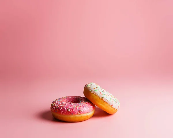 Два Сочных Свежих Сладких Пончика Сахарной Глазурью Посыпками Розовом Фоне Стоковое Изображение