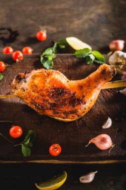 Tavuk kalça sarımsak biber yerleştirilmiş bir siyah Ahşap doğrama kurulu ızgara.