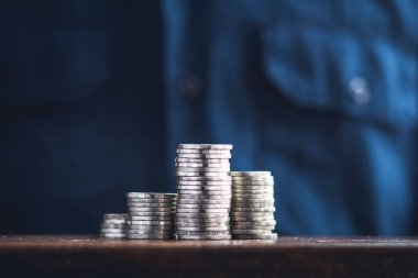 Gümüş para sikke ve mavi tişörtlü adam el