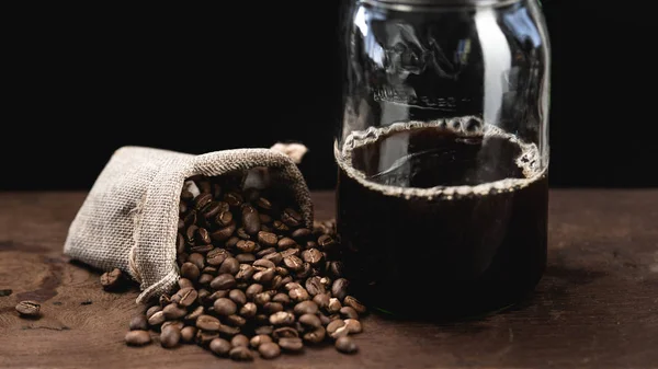 Czarna kawa wlewa się rano do szklanki. — Zdjęcie stockowe