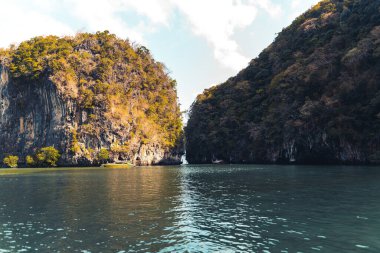Ada ve berrak su, Sahil-Mavi deniz ve kayalık dağlar, 