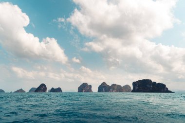 Ada ve berrak su, Sahil-Mavi deniz ve kayalık dağlar, 