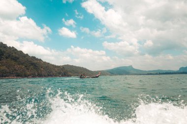Ada ve berrak su, Sahil-Mavi deniz ve kayalık dağlar, 