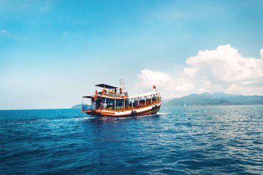 Adada temiz su, açık mavi deniz ve ahşap tekne.