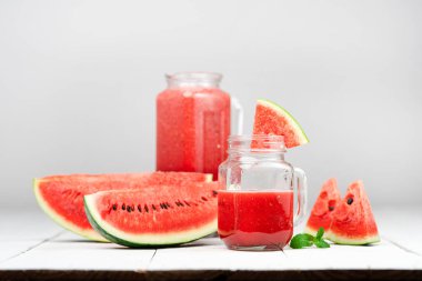 Karpuz suyu, cam karpuz dilimleri, ahşap beyaz arka planda