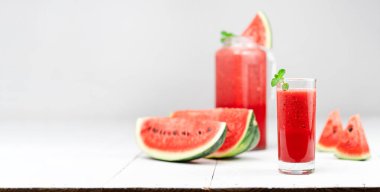 Karpuz suyu, cam karpuz dilimleri, ahşap beyaz arka planda