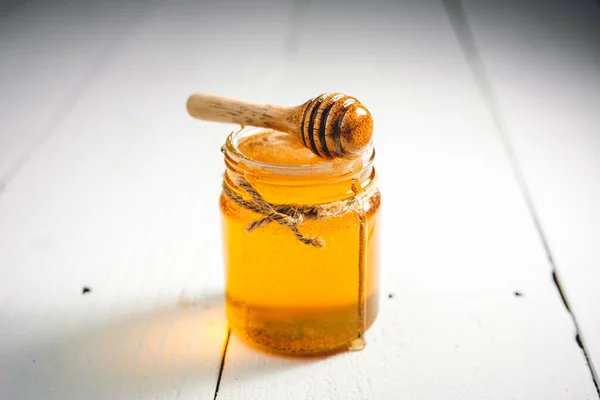 Χρυσό Μέλι Γυάλινο Μπουκάλι Λευκό Ξύλινο Πάτωμα Σέσουλα Μελιού — Φωτογραφία Αρχείου