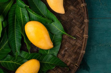 Yaprağın üzerindeki mangoların yakın çekimi Masadaki