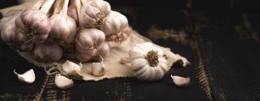 Siyah ahşap arka planda sarımsak, sarımsaklı baharat.