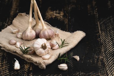Siyah ahşap arka planda sarımsak, sarımsaklı baharat.
