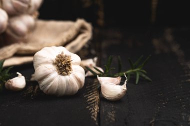 Siyah ahşap arka planda sarımsak, sarımsaklı baharat.
