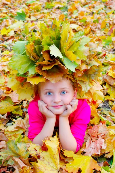 Girl with a wreath of yellow leaves smiles — Stock Photo, Image