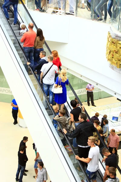Pessoas na escada rolante no supermercado — Fotografia de Stock