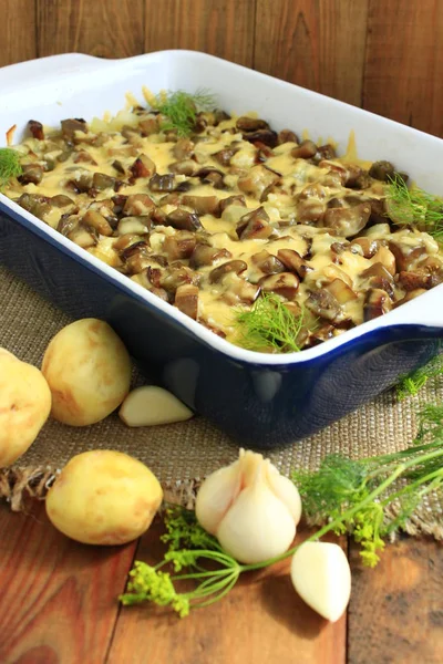 Stewed potatoes with slices of eggplant under melted cheese and garlic — Stock Photo, Image