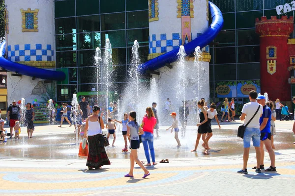 Viele Kinder spielen im heißen Sommer auf dem Spielplatz mit Springbrunnen — Stockfoto