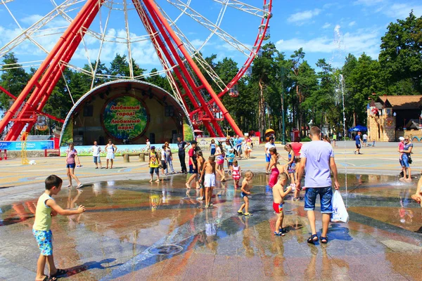 Molti bambini giocano nel parco giochi con fontane nella calda estate — Foto Stock