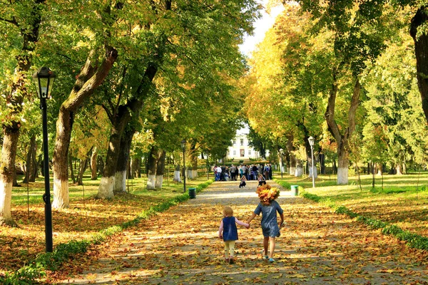 Young happy sisters run in the autumnal park — Stock Photo, Image