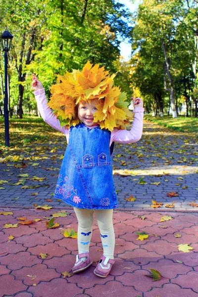 Bebê brinca com folhas de outono no parque — Fotografia de Stock