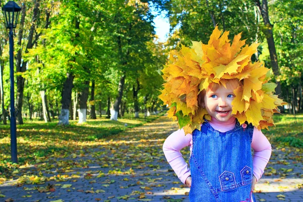 Baby plays with Autumn leaves in the park — Stock Photo, Image