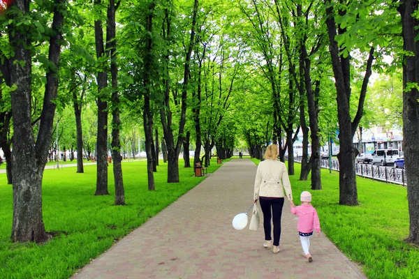 Mãe e sua filha caminham no parque da cidade — Fotografia de Stock