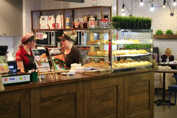 Tyttö ottaa tilauksia kahvilassa herkullisia croissanteja — kuvapankkivalokuva