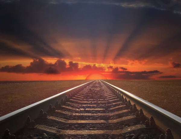 Rotaie che vanno via nel rosso fuoco del tramonto — Foto Stock