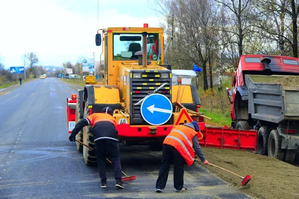 Road-roller and repairmen make a repair of the road — Stock Photo, Image