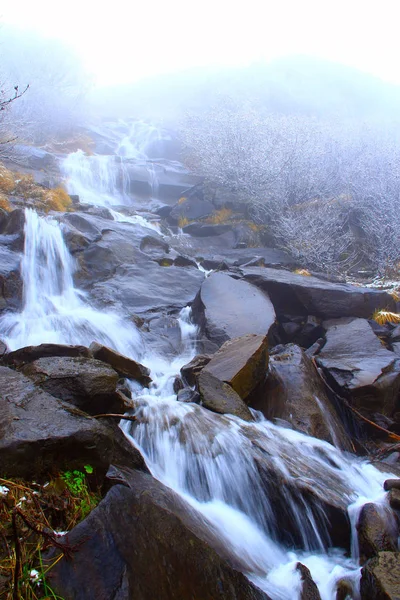 Вода падає з водоспаду між камінням — стокове фото