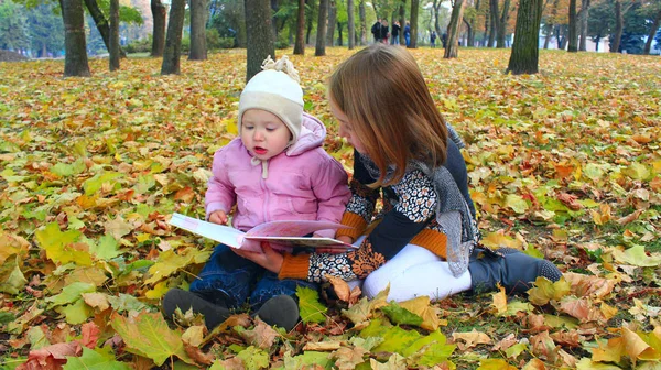 Małe dziewczynki czytaj książce jesienny Park. Wypoczynku na łonie natury — Zdjęcie stockowe