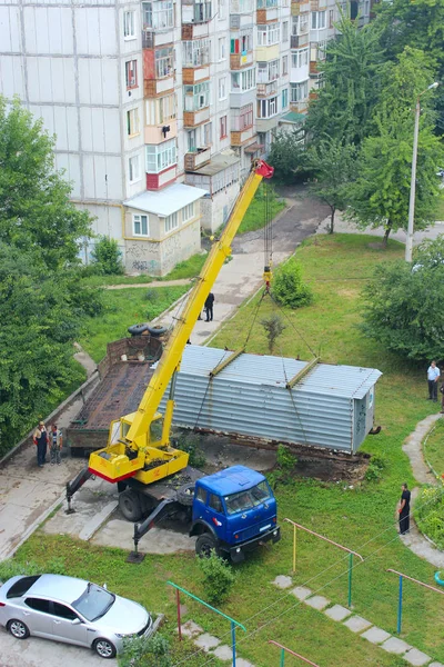 Промышленный кран поднять контейнер коробки, чтобы загрузить его на борт грузовика — стоковое фото