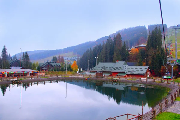 Lac pittoresque et maisons de tourisme en ski ukrainien Bukovel. Paysage avec lac de montagne en station balnéaire — Photo