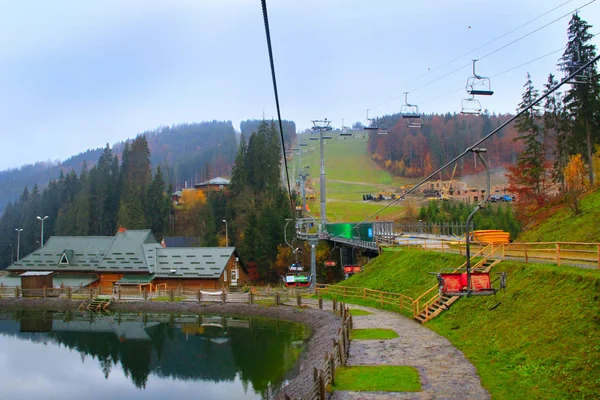 Picturesque lake and tourist houses in ukrainian ski Bukovel. Landscape with mountain lake in resort town
