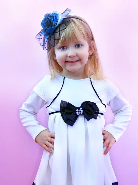 Malá holčička v módní elegantní klobouk s úsměvem a Pózování na lila pozadí — Stock fotografie
