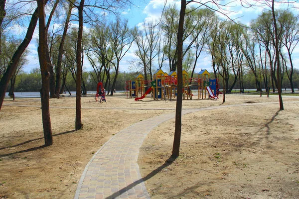 Chodnik prowadzący do dziecinna plac zabaw w parku miejskim. Nowoczesny plac zabaw dla dzieci — Zdjęcie stockowe