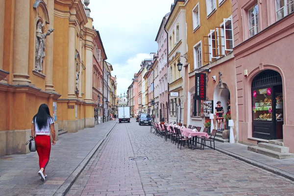 Mädchen in roten Hosen, die durch die Stadt laufen. Schöne Architektur und Café auf der Straße — Stockfoto