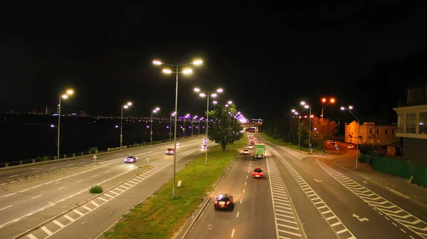 Multiband αυτοκινητόδρομο στη μεγάλη πόλη με αυτοκίνητα που πηγαίνουν τη νύχτα. Αυτοκίνητα οδηγούν στην εθνική οδό — Φωτογραφία Αρχείου